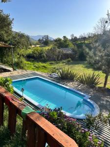 una piscina en una terraza con un banco de madera en Cabaña Modesto, en Olmué