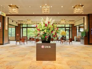 a lobby with a large vase of flowers on a table at Yukai Resort Hana-Saichoraku in Kaga