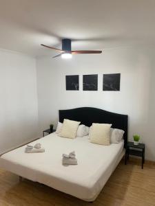 a bedroom with a bed with a ceiling fan at Beach Villa private heated pool in Caleta De Fuste