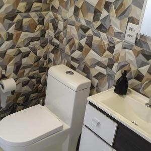 uma casa de banho com um WC e um lavatório em GUI e LU ACOMODAÇOES em Penha