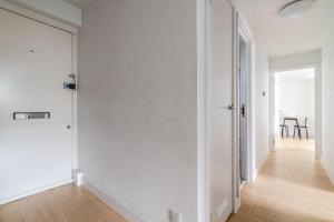 an empty hallway with white walls and a wooden floor at Belgravia Apartment 41 in London