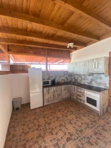 a kitchen with a white refrigerator in a room at Beach Villa private heated pool in Caleta De Fuste