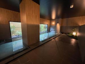 a swimming pool in a building with a glass floor at Hotel Route Inn Ohi Takahama in Takahama