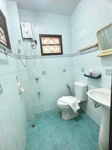 a bathroom with a toilet and a sink and a window at Soft Resort Kad Farang Hangdong in Ban Yang Plao
