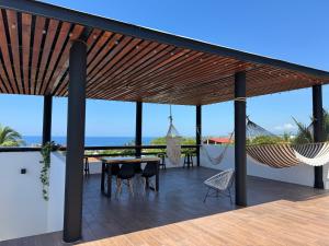 un patio con hamaca, mesa y sillas en Casa Mura, en Puerto Escondido