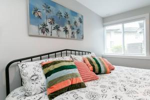 ein Schlafzimmer mit einem Bett mit Kissen und einem Fenster in der Unterkunft Stylish 1 Bedroom Suite with Lake Access in Victoria
