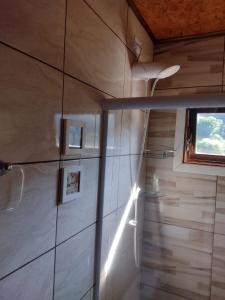 uma casa de banho com um chuveiro e uma janela em Chalés Fenix em Santo Antônio do Pinhal