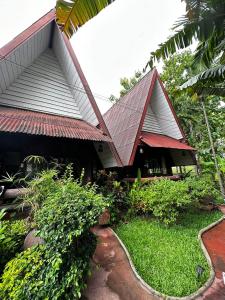 a house with a tin roof and a path at Soft Resort Kad Farang Hangdong in Ban Yang Plao