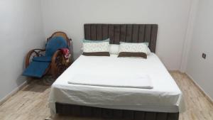 a bedroom with a large white bed with a wooden headboard at Sweet home 1 in Mansoura