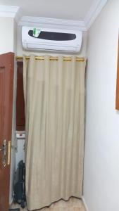 a bathroom with a heater and a shower curtain at Sweet home 1 in Mansoura
