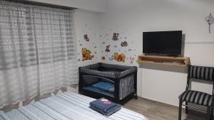 Habitación con cuna, TV y cama en casa a 20 minutos del aeropuerto de Ezeiza sobre avenida opcional tranfer amplio parque para mascotas rejas y cámaras de seguridad en Monte Grande
