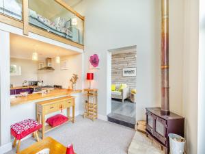 a kitchen and living room with a wood stove at Hallmark Annexe in Tenterden
