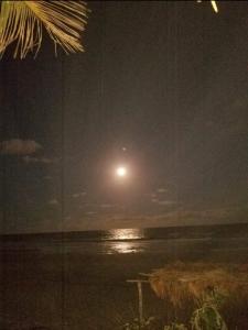 a full moon rising over the ocean at night at Quarto com ar condicionado, WiFi in Tareco