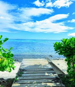 a wooden pathway to the beach with the ocean at MOOREA - Fare Taina Nui in Haapiti