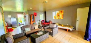 a living room with couches and a table at MOOREA - Fare Taina Nui in Haapiti