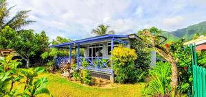 uma casa com um telhado azul num jardim em MOOREA - Fare Taina Iti em Haapiti