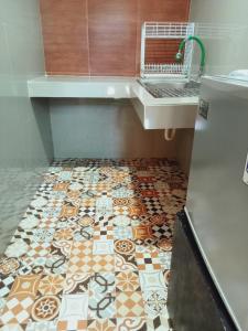 a bathroom with a tile floor with a sink at Buratwangi Tropis House in Kerobokan +21 photos