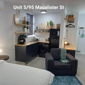 a room with a bed and a chair and a kitchen at At Home Apartments in Sale