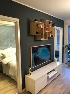ein Wohnzimmer mit einem TV und einem Bett in der Unterkunft Fantastisk leilighet med grillområde og klatrevegg in Bergen
