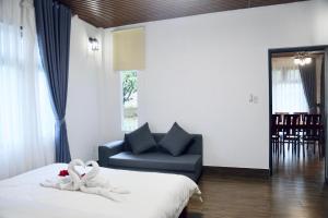 Postel nebo postele na pokoji v ubytování JE T'AIME VILLA - Khu nghỉ dưỡng nhà vườn nằm giữa thiên nhiên bao la hoa cỏ