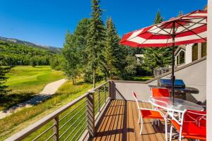 a patio with a table and an umbrella on a deck at Homestead Townhome in Snowmass Village