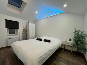 ein Schlafzimmer mit einem großen weißen Bett und einem blauen Licht in der Unterkunft Serenity Home Hayange in Hayange