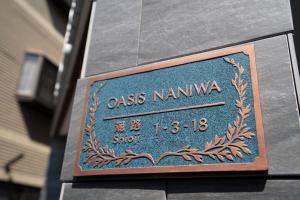 ein Schild an der Seite eines Gebäudes in der Unterkunft OASIS NANIWA in Osaka