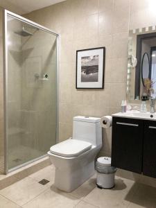 ein Bad mit einer Dusche, einem WC und einem Waschbecken in der Unterkunft Tu Apartamento en Coronado in Chame