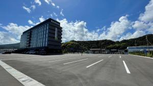 a parking lot with a large building in the middle at Hotel Route Inn Ohi Takahama in Takahama
