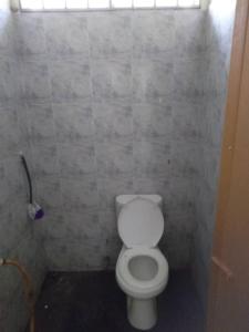 een badkamer met een wit toilet in een kamer bij Familia Homestay Tepi Sawah in Pasir Mas