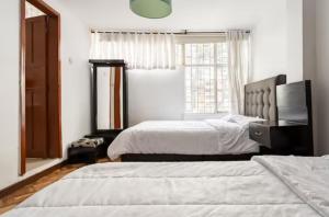 1 dormitorio con 2 camas y ventana en CASA FLORES en Bogotá