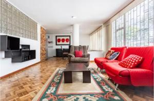 sala de estar con muebles de color rojo y sofá rojo en CASA FLORES, en Bogotá