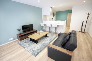 een woonkamer met een bank en een tafel bij OASIS NANIWA in Osaka