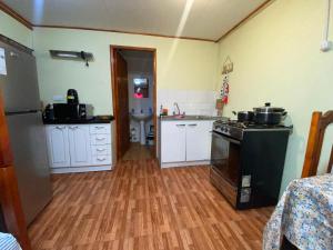 cocina con fregadero y fogones horno superior en Cabañas Dichato Turismo Roma, en Dichato