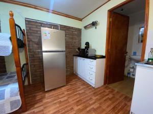 cocina con nevera en una habitación en Cabañas Dichato Turismo Roma, en Dichato