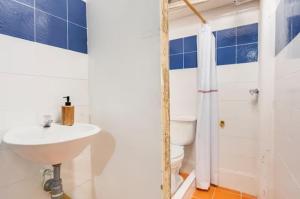 a white bathroom with a sink and a toilet at CASA FLORES in Bogotá