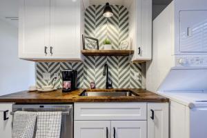 a kitchen with white cabinets and a sink at 5 min Grant park with Fenced Yard Parking Pet Friendly in Atlanta