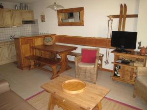 ein Wohnzimmer mit Tisch und Fernseher in der Unterkunft Appartement 3P, 6 pers, proche pistes, balcon exposé Sud, parking privé, TV, cuisine équipée - FR-1-762-5 in Le Monêtier-les-Bains