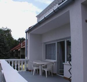 a patio with a table and chairs on a balcony at Jartó Apartman in Harkány