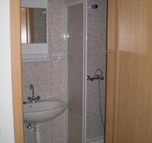 a bathroom with a sink and a shower at Jartó Apartman in Harkány