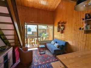 a living room with a blue couch and a window at Appartement La Clusaz, 3 pièces, 6 personnes - FR-1-459-211 in La Clusaz