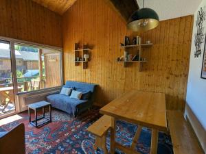 a living room with a table and a couch at Appartement La Clusaz, 3 pièces, 6 personnes - FR-1-459-211 in La Clusaz