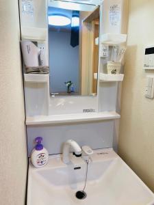 uma casa de banho com um lavatório com um espelho e um lavatório em *Fortune House*鶴見橋 花園町駅 *生活機能完備* 一軒家 *最大4人* em Osaka