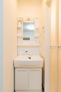 uma casa de banho com um lavatório branco e um espelho. em *Fortune House*鶴見橋 花園町駅 *生活機能完備* 一軒家 *最大4人* em Osaka