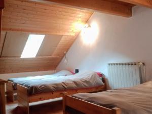 two beds in a room with a attic at Chalet spacieux 6 pièces avec cheminée, barbecue, près des pistes, parking privé - FR-1-762-43 in Le Monêtier-les-Bains
