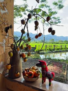 un tavolo con un cesto di frutta accanto a una finestra di An's House a Ha Giang