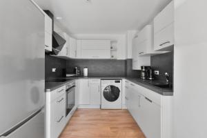 a white kitchen with white cabinets and a dishwasher at 1890 Apartments Bayreuth in Bayreuth
