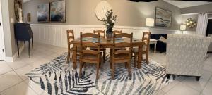 a dining room with a table and chairs on a rug at Ocean Walk Beach and Sun New Smyrna Beach in New Smyrna Beach