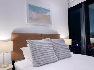 - un lit blanc avec un tas d'oreillers dans l'établissement Brisbane Riverfront Oasis 2Bed Panoramic RiverView, à Brisbane