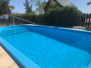 a large blue swimming pool in a yard at Cabañas La Soñada del Río in Victoria